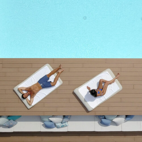 Due persone prendono il sole a bordo piscina
